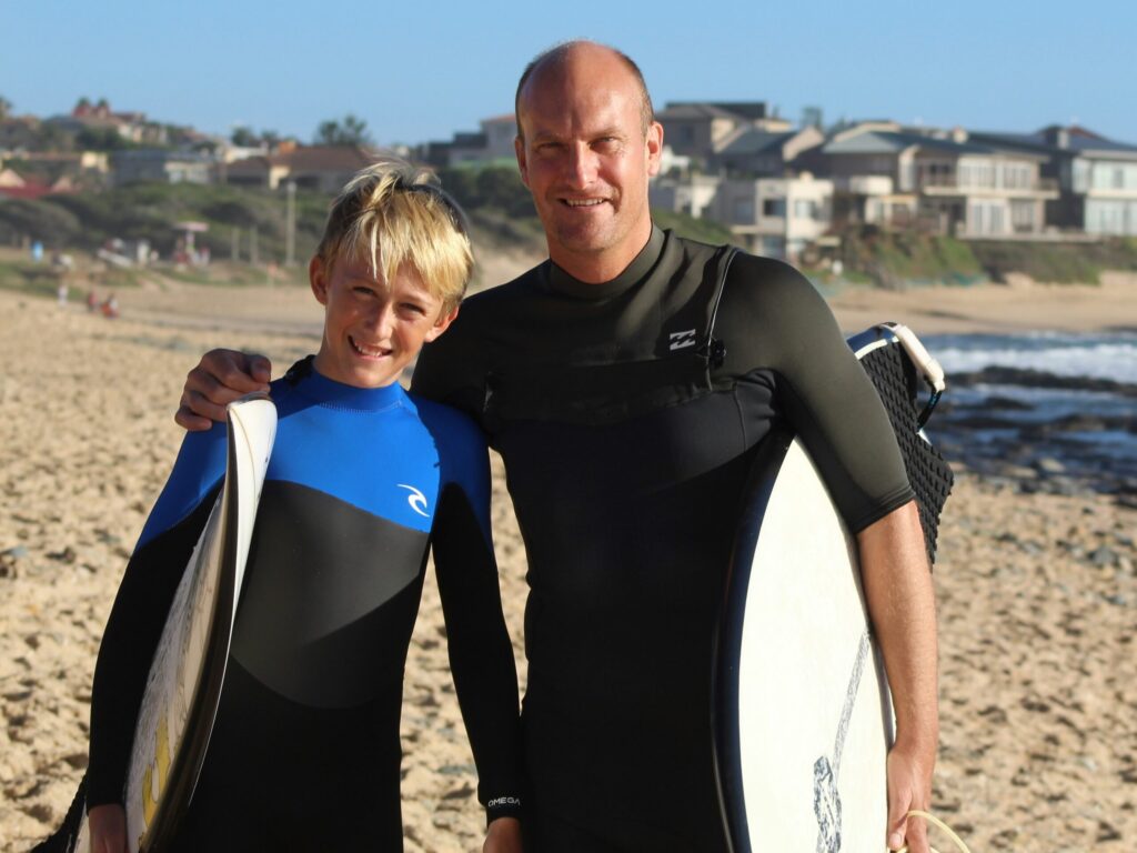 Father son surfers on beach